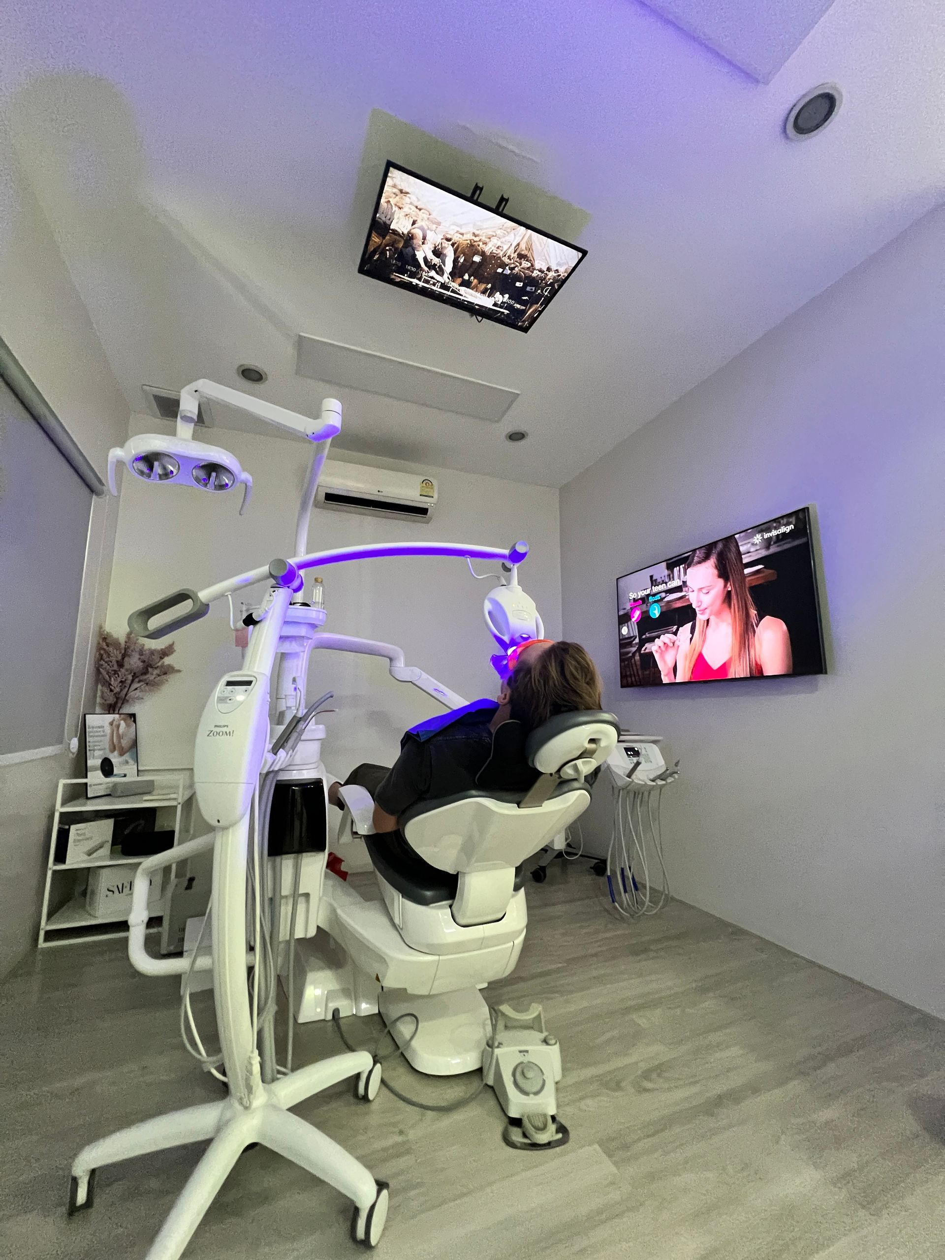 Patient comfortably reclined under Zoom whitening light